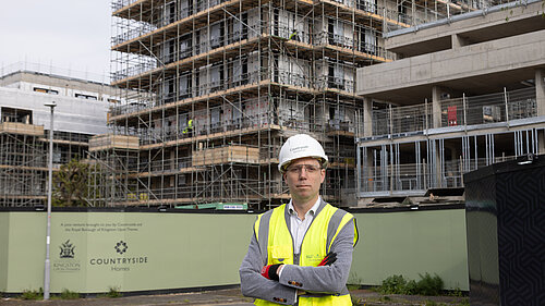 Rob Blackie pictured in front of a construction site, wearing a hi-vis with a white hardhat