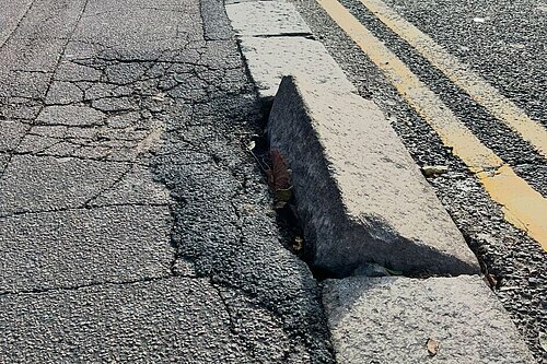 A damaged kerb stone on Higham Hill Road